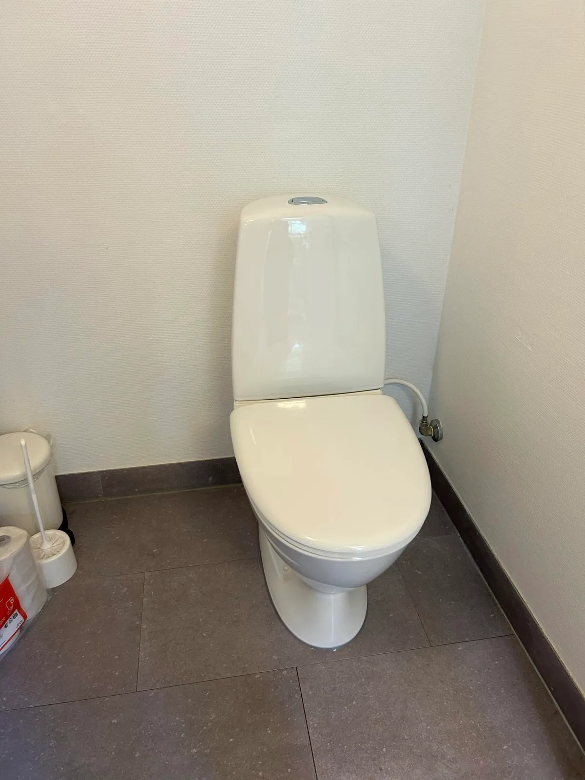 Nyt hvidt gulvstående toilet med tilslutning ved væggen